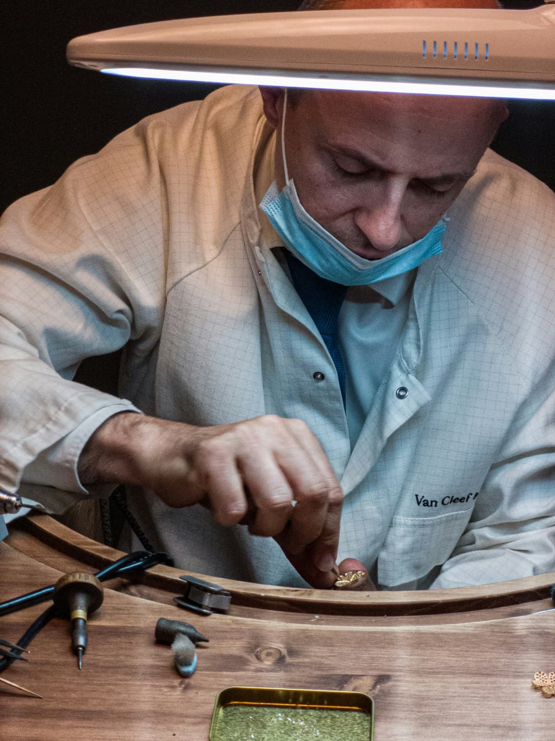 Master craftsman working on intricate gold jewelry with traditional tools in workshop