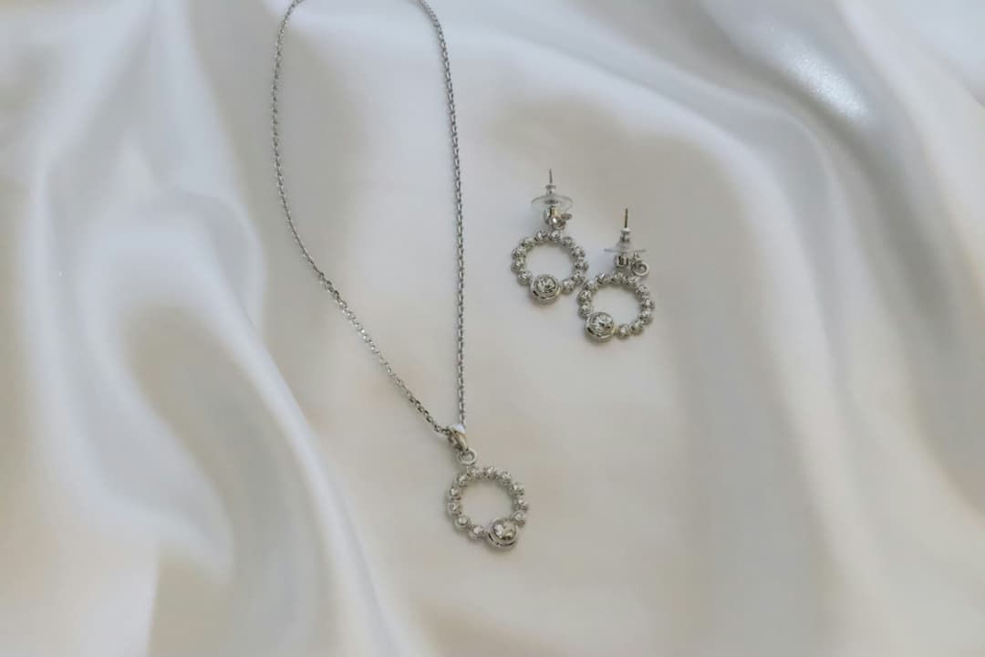 Elegant bridal jewelry set with gold necklace and matching earrings on silk fabric