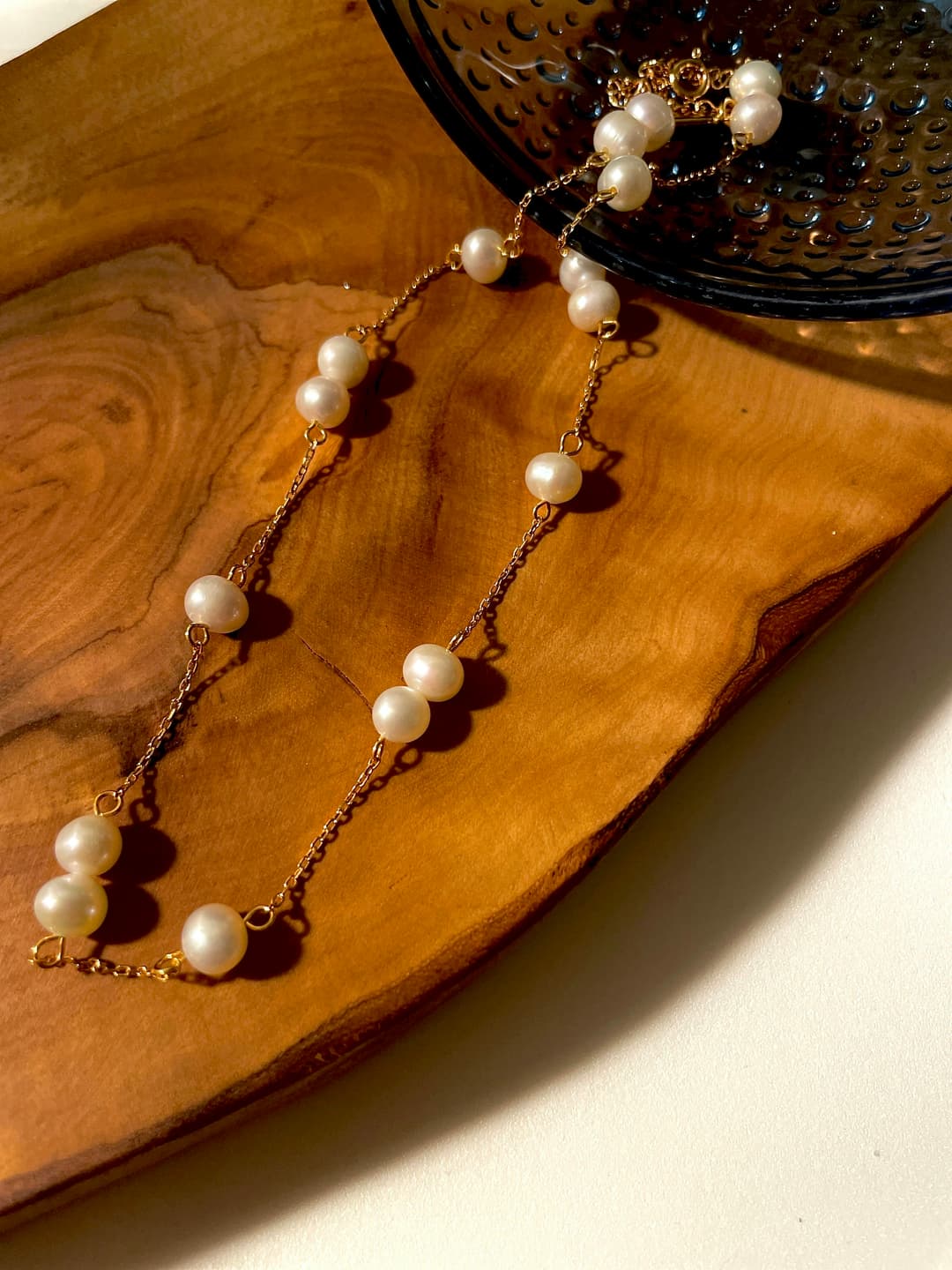 Vintage pearl necklace with gold clasp on dark wooden surface