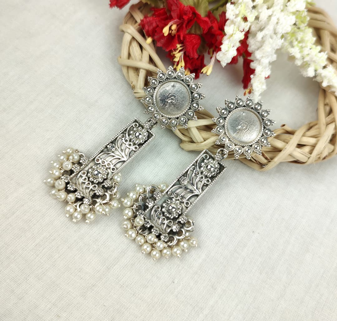 Modern silver earrings with geometric design on white background